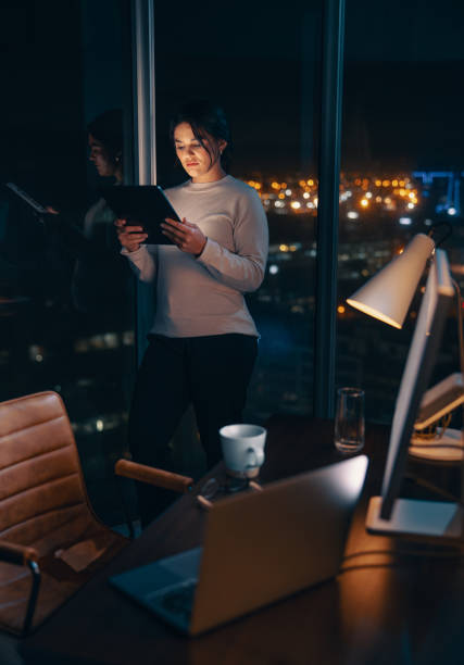 istock Business woman working late in her office, using a tablet to analyse data 1674139686