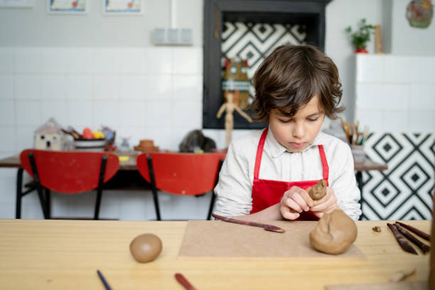 istock A school boy concentrating on his clay modelling 1674142827