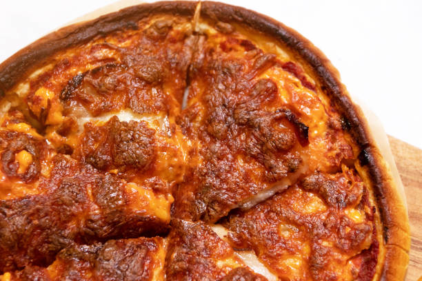 istock Burnt pizza with cheese on wooden cutting board. 1674143601