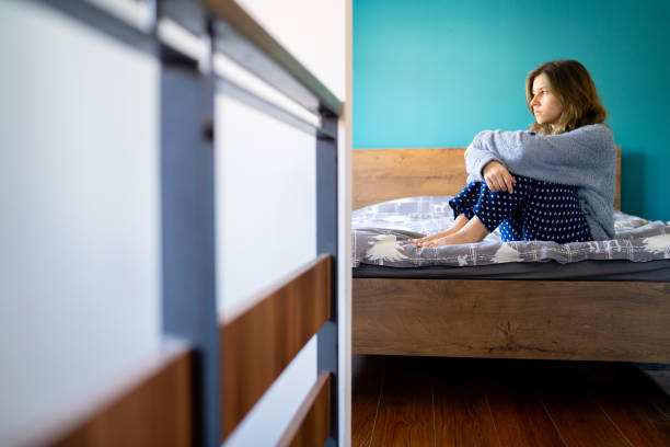 istock A young woman sitting on a bed 1674147962