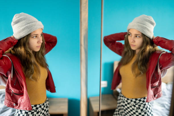 istock Young woman looking at her reflection in a mirror 1674148497