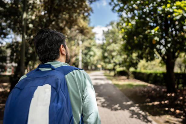 Rear view of a man walking through the park