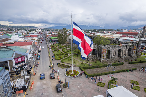 Beautiful View of the Costa Rica Flag with the Bicentennial Angel in Cartago, next to the Ruins and the basilica - Costa Rica Patriotic Symbols