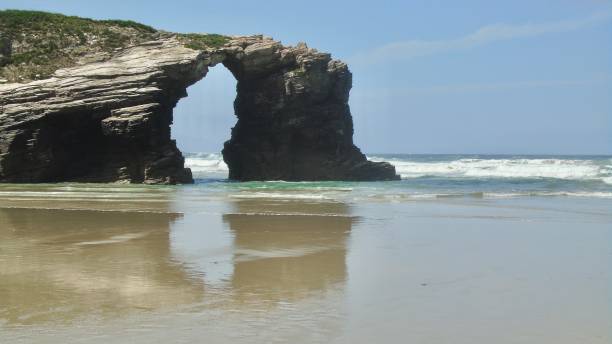 istock dramatic limestone sea arches are reflected on shiny wet sands at as catedrais beach in northern spain. 1674202594