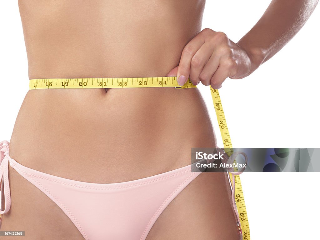 Joven mujer medir su cintura delgada con una cinta - Foto de stock de 20 a 29 años libre de derechos