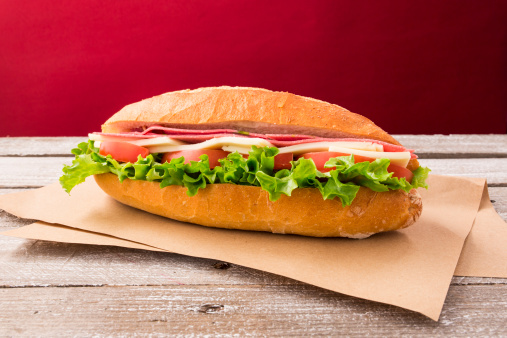 Delicious submarine sandwich on a wooden background