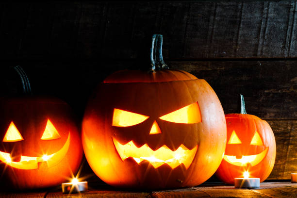 istock Three Halloween Pumpkins and candles 1674245305