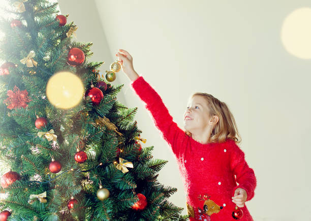 istock small girl decorates a Christmas tree 1674248346