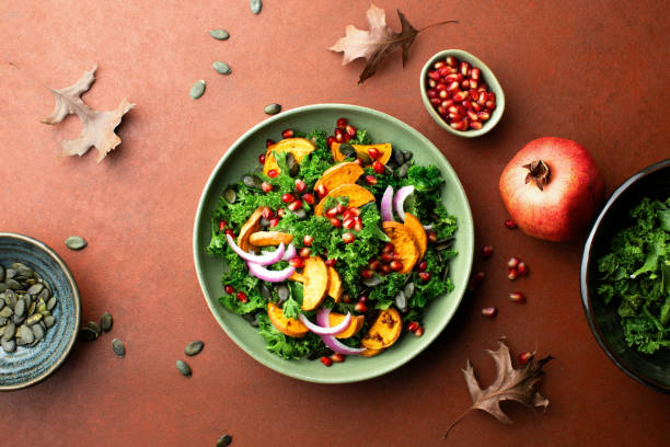 Kale, roasted sweet potato and pomegranate salad Kale, roasted sweet potato and pomegranate salad, top down view winter food top view stock pictures, royalty-free photos & images