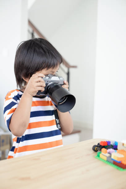 istock Asian kid with camera. Child learning how to take photograph. 1674254944