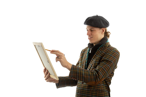 Young smiling artist with a beret on his head on a white background