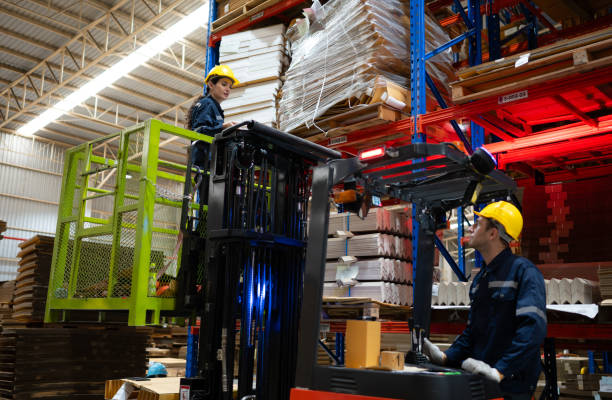 istock Warehouse workers using forklift to check and counting in a large warehouse. This is a large paper package storage and distribution warehouse. 1674275005