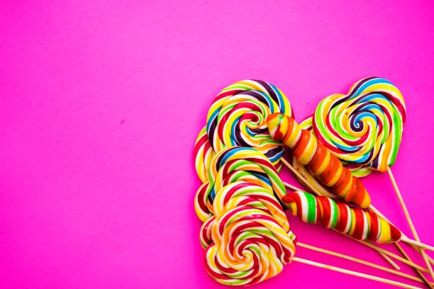 multicolored, different sweets, lollipops on a pink background. Copy space. Top view, sweets concept