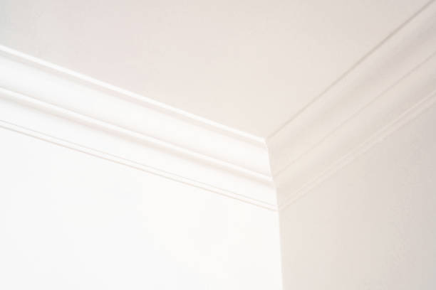 Modern wall and ceiling plaster Detail of a corner in a room, where two walls and ceiling are joined by a plaster moulding, painted in off-white magnolia. Magnolia stock pictures, royalty-free photos & images