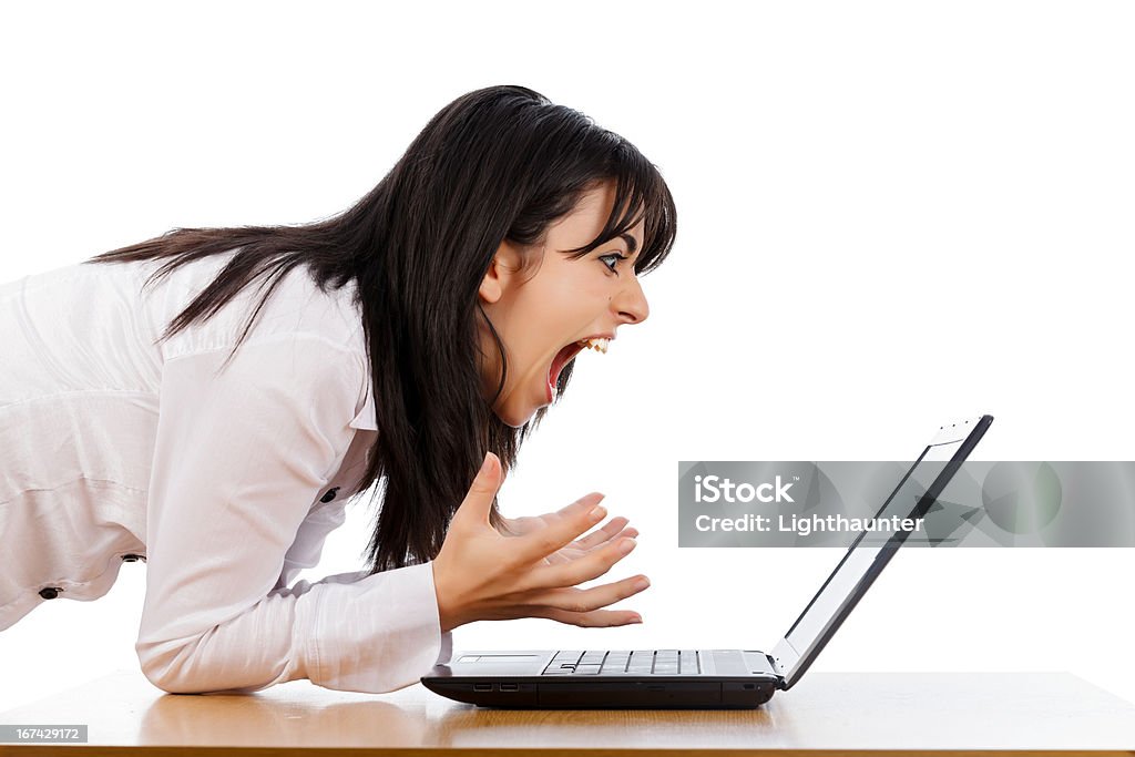 Hate Technology Woman screaming nervously at the laptop isolated on white. Shouting Stock Photo