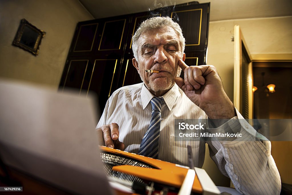 Sênior homem escrevendo em uma máquina de escrever - Foto de stock de Cigarro royalty-free