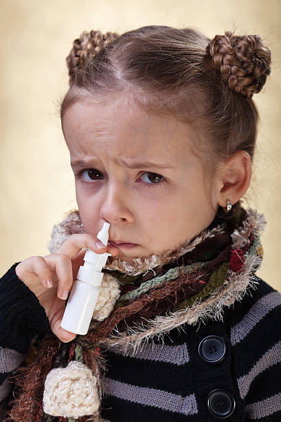 niña con la gripe con atomizador nasal - child human nose allergy spraying fotografías e imágenes de stock