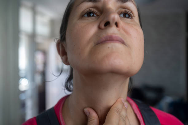 istock Women with thyroid gland problem with hands holding throat 1674369420
