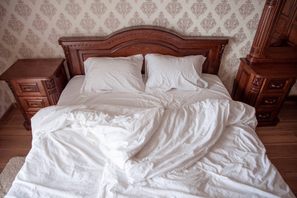 Bedroom interior. Wooden bed with pillows and with white linen