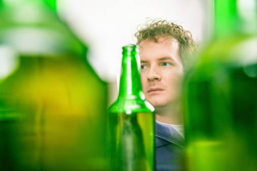 Young male portrait through beer bottles.