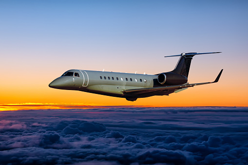 Modern luxury private jet fly in the sunrise sky
