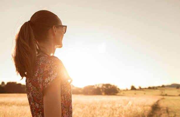 Portrait of a beautiful young woman standing in a wheat field
