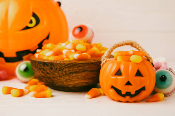 istock Halloween candy corn,jelly eye, pumpkin candy, sugar skull in different bowls on white background.Classic candy sweets for Halloween with.Halloween holiday concept with candy corn and jack o lantern. 1674404957