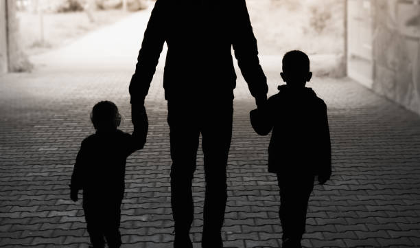 istock Father holding hands with children walking through a tunnel. 1674404978