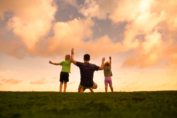istock Father with children enjoying beautiful sunset. 1674406619