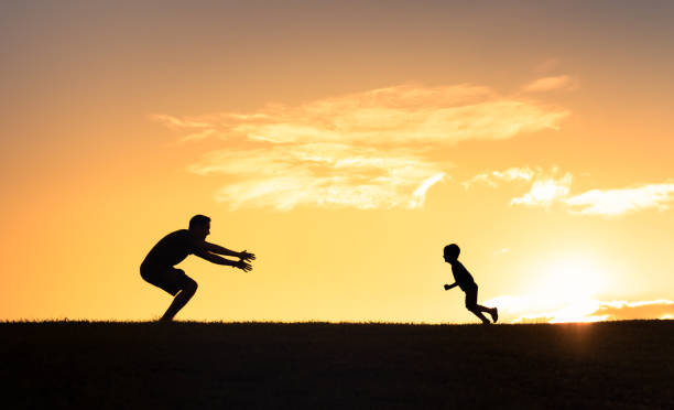 istock Father and son playing together outdoors at sunset. 1674408064