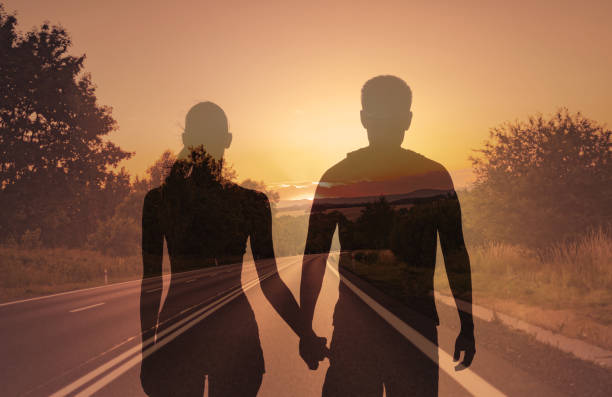 istock Couple holding hands walking down country road. 1674408829