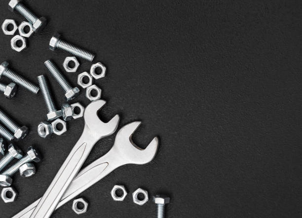 istock Wrenches with bolts and nuts on black background. Top view. Copyspace.. 1674416636