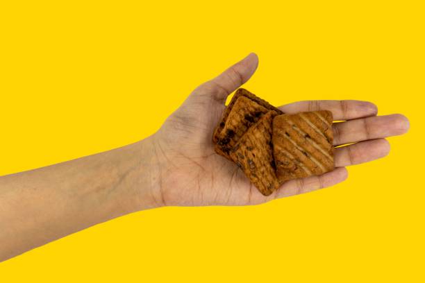 istock Choco Chips Biscuits Tasty And Yummy On Hand, Isolated on Yellow Background 1674429640