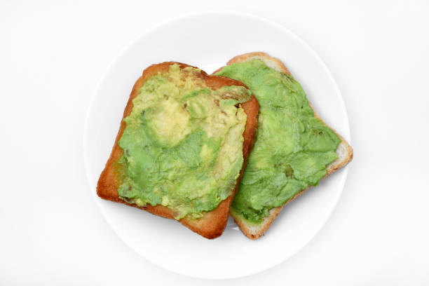 istock Avocado pasta on fried toast. Vegetables spread on bread. Vegan breakfast on a white plate. 1674453606