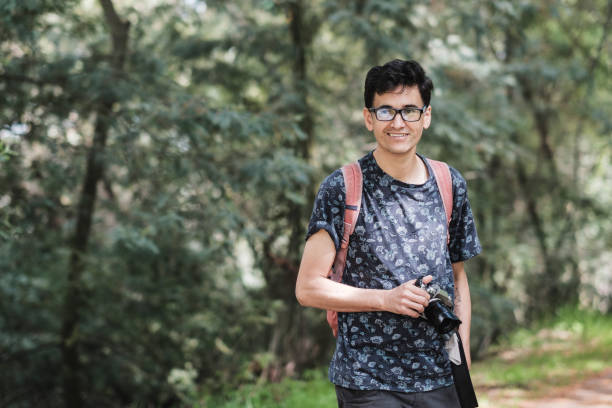istock adult man with camera walking through park 1674457841