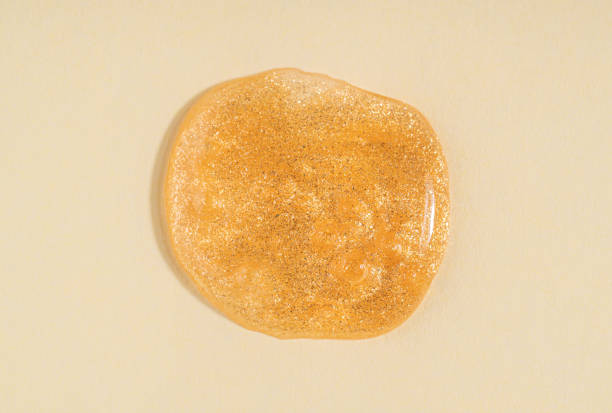 istock Transparent shimmer golden cosmetic sample texture with bubbles. Cosmetic glittering shower gel. Cosmetic shiny face serum, lotion, moisturizer, beauty background 1674458404