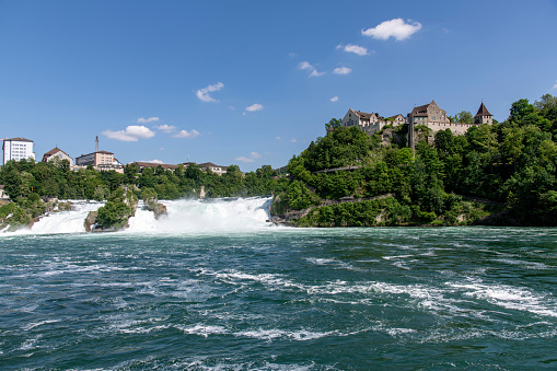 Panoramic view over the Rhine falls (Rheinfalle) near Schaffhausen, Switzerland against a white clouded blue sky