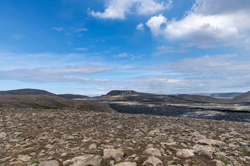 Panoramic view over landscape and lava field near mountain Fagradalsfjall, Iceland, with fissure vent of 2021 Geldingadalir volcano area against a white clouded blue sky