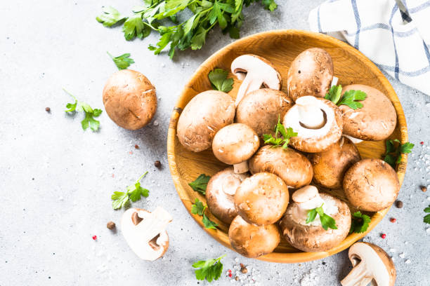 istock Champignon. Fresh organnic mushrooms at black background. 1674468932
