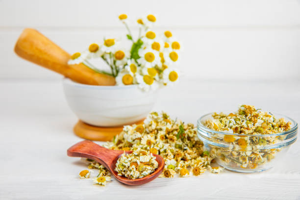 istock Dry chamomile flowers on a wooden table. Soothing chamomile tea. Herbal drink. flat layout. Space for text.Copy space.Medical prevention and immune concept. Folk alternative medicine. 1674471900