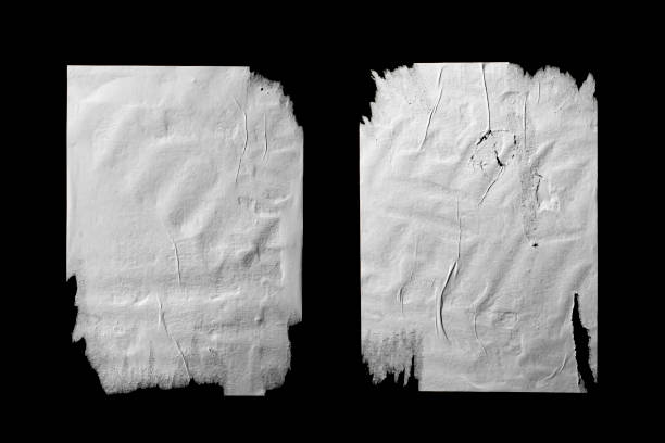 istock Two sheets of white torn paper with folds isolated on a black background. 1674490055