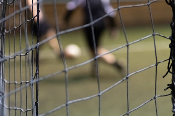 Futsal soccer players during the match. Blurred background selective focus, space for copy.