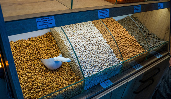 Different spices, grains and herbs such as sunflower seed, white and brown chickpeas kept for display in a shop