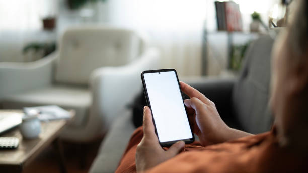 istock Woman using phone with white screen while lying on sofa at home , mock up screen 1674493760
