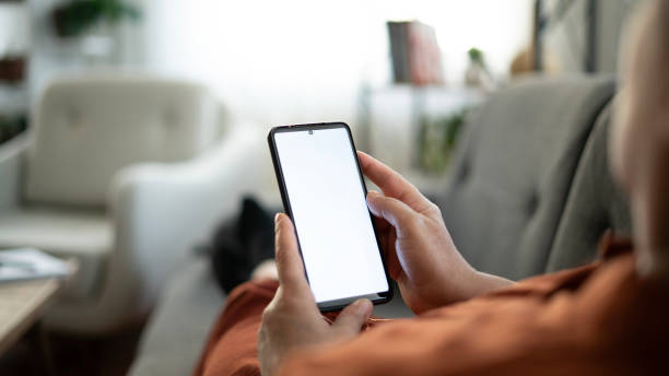 istock Woman using phone with white screen while lying on sofa at home , mock up screen 1674493761