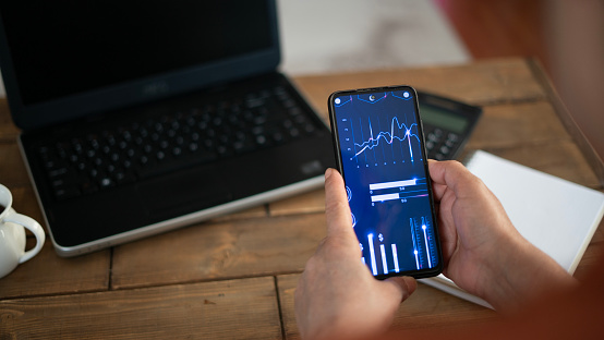 Adult woman follows stock market on phone