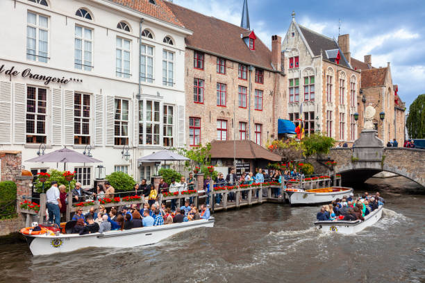 Tourists on a sight seeing boat trip on the Brugge Zeebrugge Canal, Bruges, Flanders, Belgium - fotografia de stock