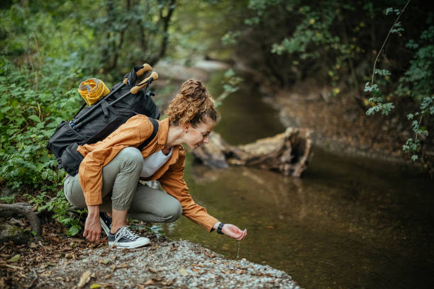 istock Woman drink water from mountain stream 1674494606