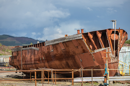 Rusting ship hull - only the shell sat in dry dock awaiting refurbishment or scrap process.