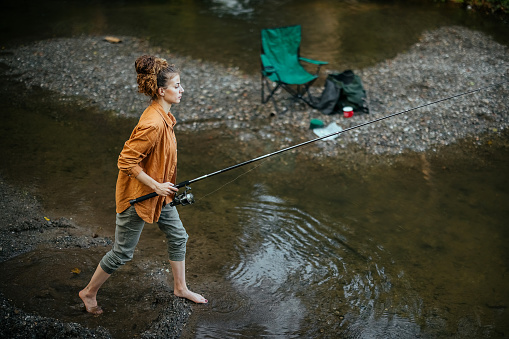 Woman enjoys fishing on the river